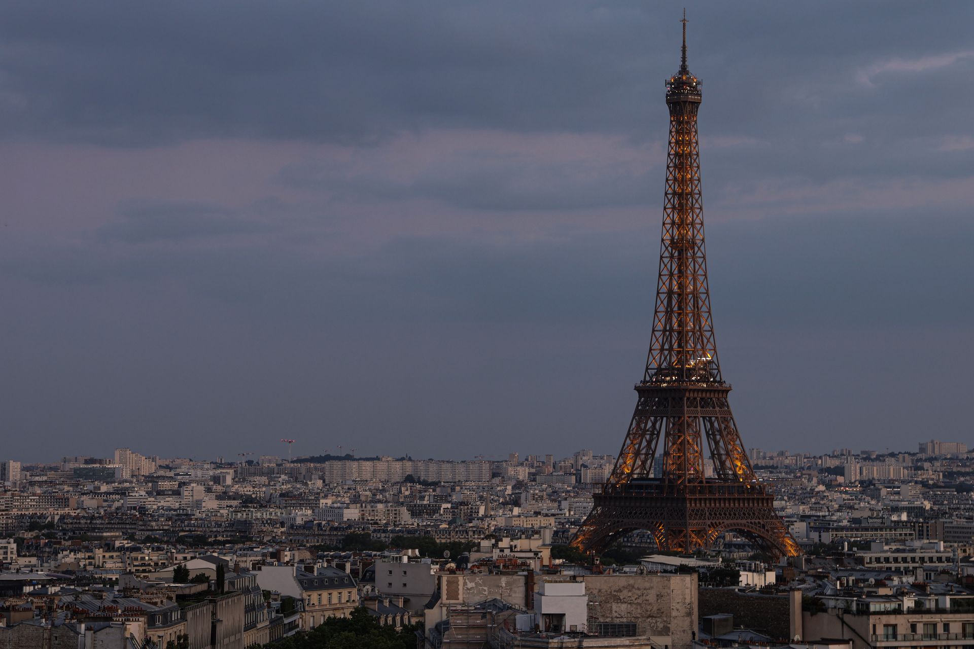 Tour Eiffel illuminée au-dessus des toits de Paris